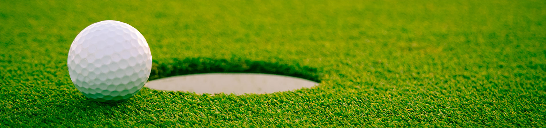 golf ball near the hole on a golf course